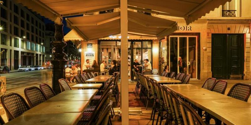 Ambiance décontractée sur une terrasse de café parisien, idéale pour un apéritif près de la 10 rue Notre Dame de Lorette 75009 Paris